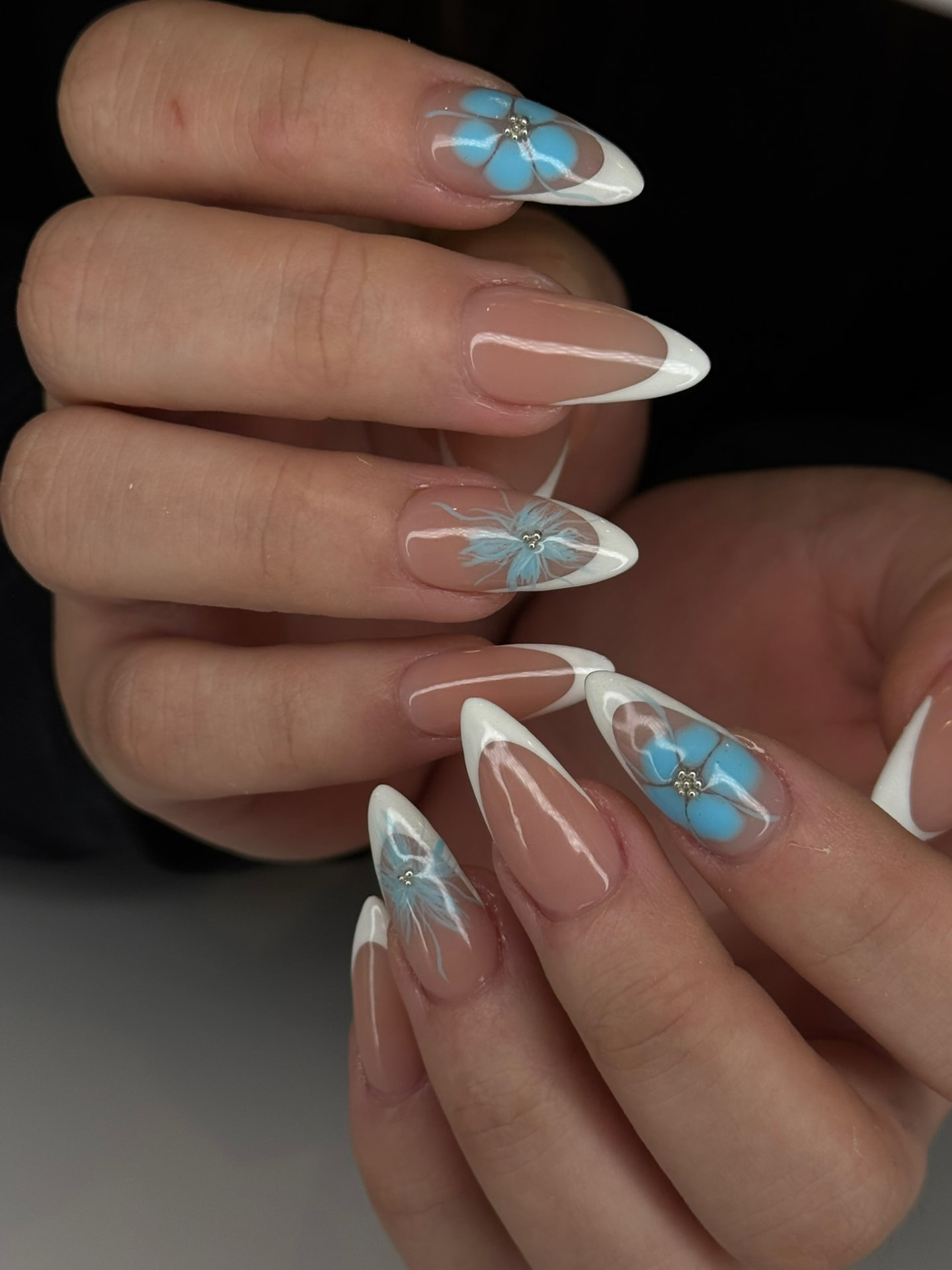 Blume Nail Bar - Luxury Nail Salon — white French almond nails with hand-painted blue floral art