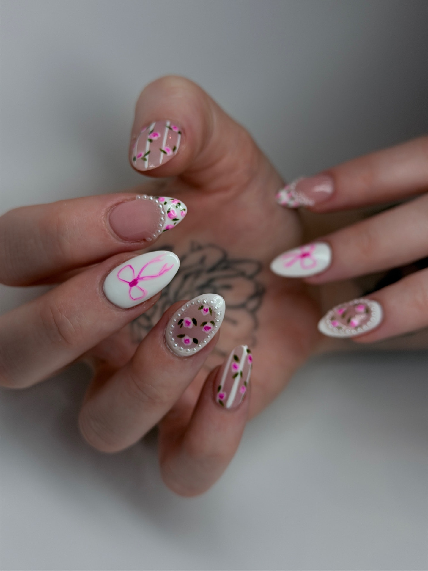 Blume Nail Bar - Luxury Nail Salon — almond nails with hand-painted pink posies, pearls and ribbon bows