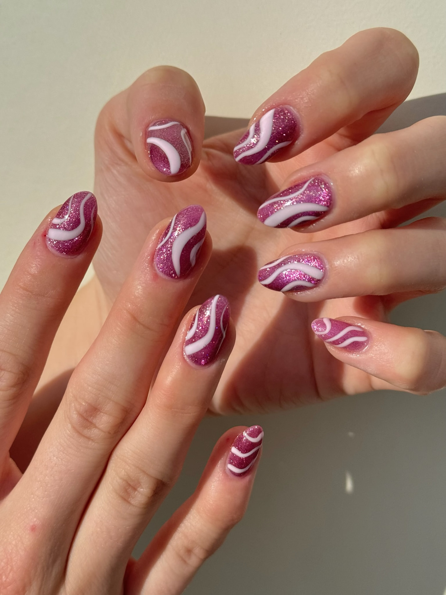 Blume Nail Bar - Luxury Nail Salon — almond nails in sparkling magenta with white swirl accents